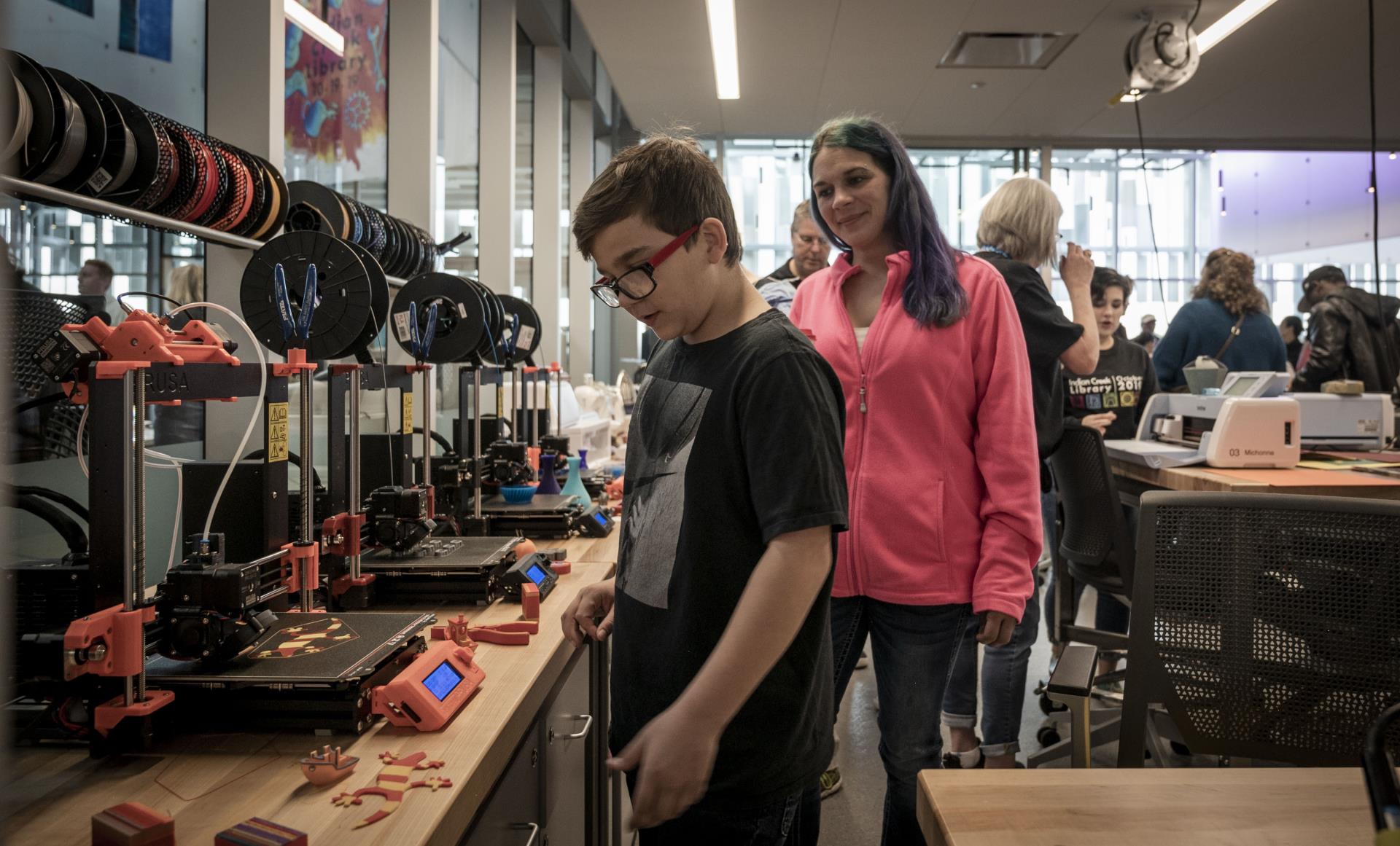 boy looking at 3D printers